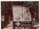 Campaña “Dele una mano a los desaparecidos", detalle de dos hojas-afiches de manos sobre muro urbano. 